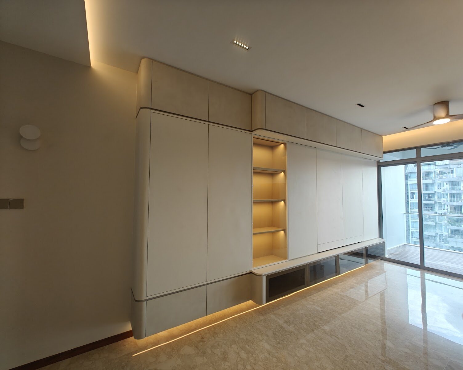 Curved cream cabinetry with a lit niche, earlier work by Aura Design & Co.