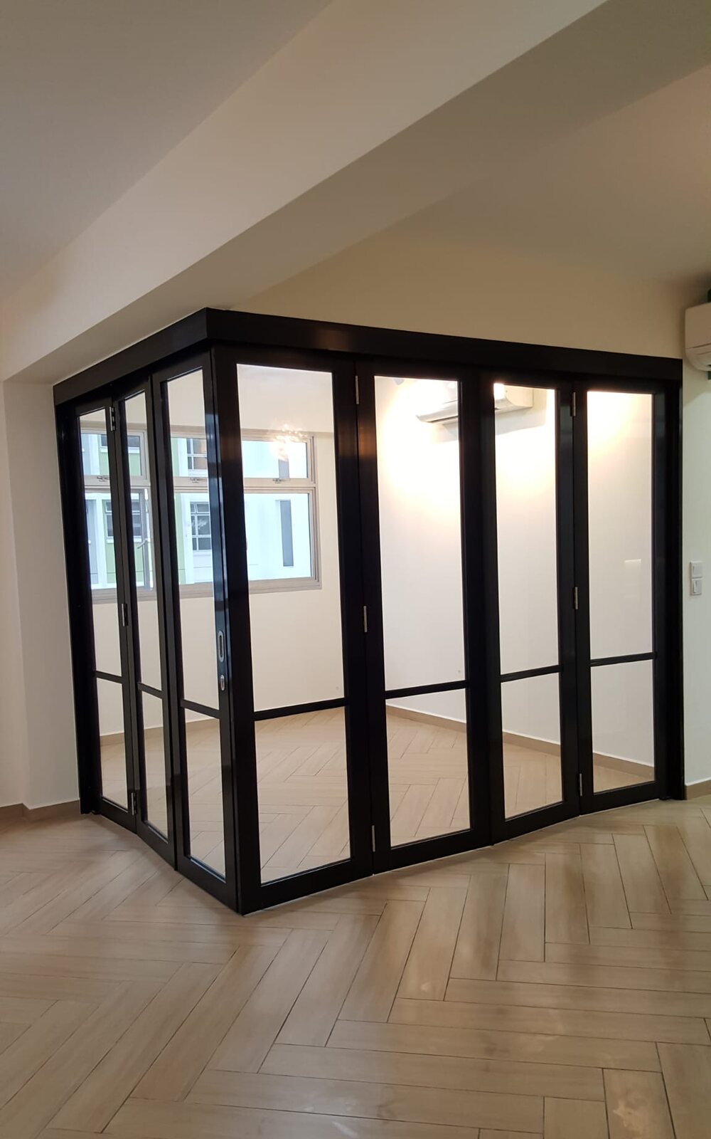 Black-framed folding glass doors on pale oak, earlier work by Aura Design & Co.