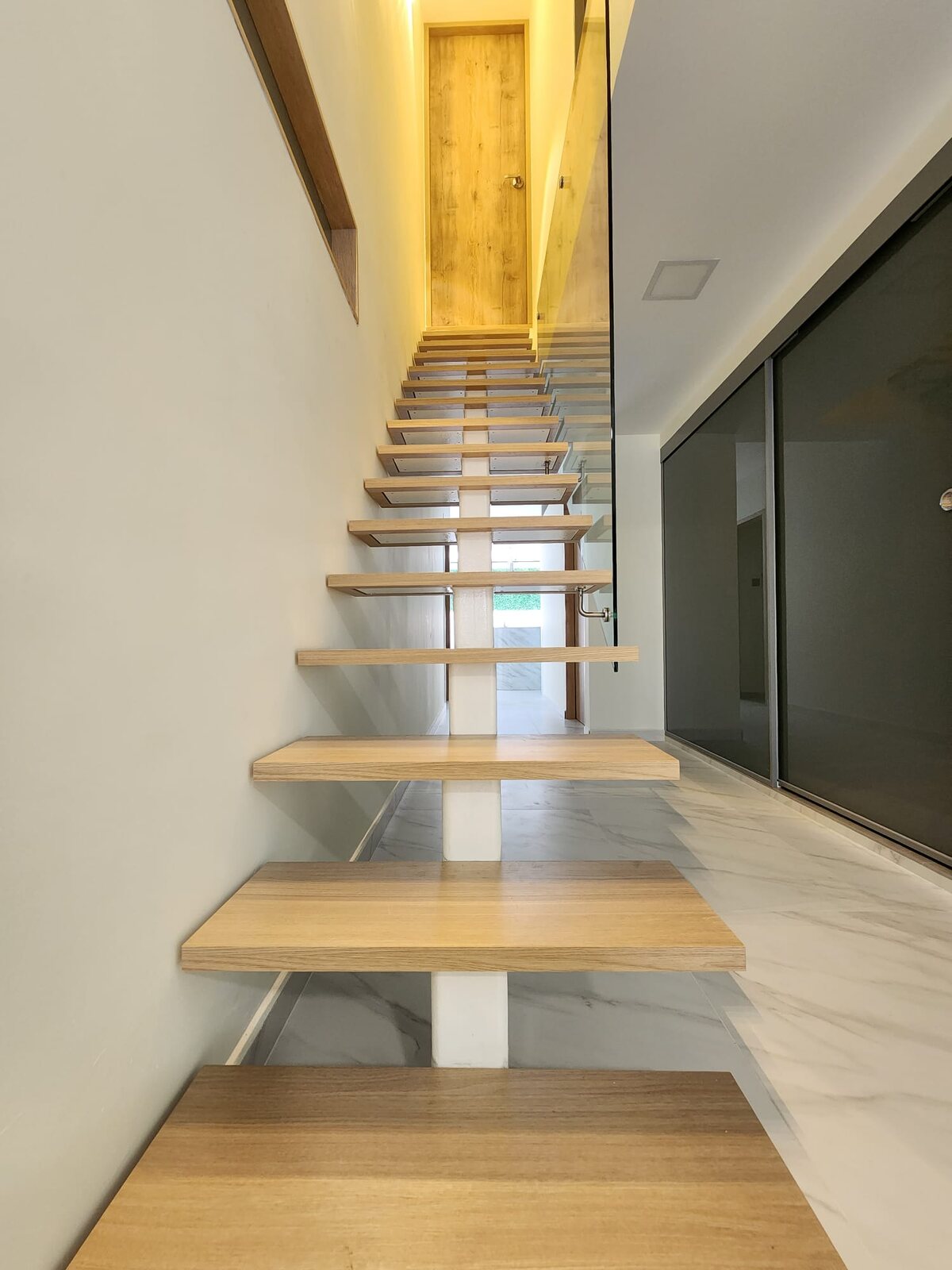 Floating oak stair over marble, earlier work by Aura Design & Co.